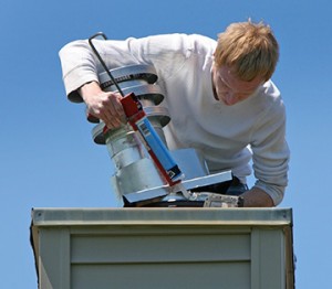 Caulking a Chimney Cap to fix leaky chimney in WI